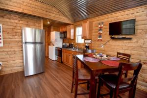 a kitchen with a refrigerator and a table with chairs at Freedom River Cabin in Utopia