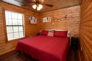 a bedroom with a red bed and a ceiling fan at Freedom River Cabin in Utopia +5 photos