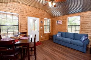 a living room with a blue couch and a table at Freedom River Cabin in Utopia