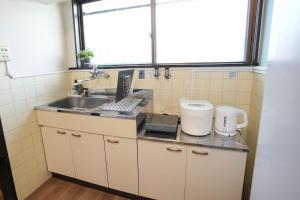 a small kitchen with a sink and a window at 302 Grand Maison konohana 予約制駐車場,USJや海遊館に最適,駅から徒歩6分 in Osaka +62 photos