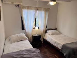 two beds in a room with a window at Yerbabuena in Yerba Buena