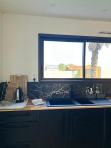 una cocina con fregadero y ventana en Villa Egret - Wifi - Jardin, en Dinard