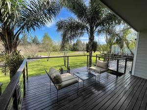 a deck with two chairs and a table at La Posada Multiespacios in Dique Luján
