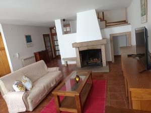 Una sala de estar con un sofá y una chimenea. en Casa Vitral - Stained Glass House, en Miranda do Douro
