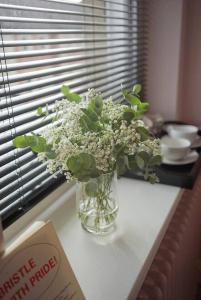 un vase de fleurs blanches assis sur une table dans l'établissement The Alma Taverns Boutique Suites - Room 5 - Hopewell, à Bristol