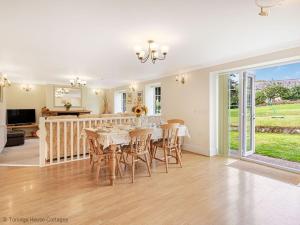 eine Küche und ein Esszimmer mit Tisch und Stühlen in der Unterkunft Hen Cottage in Little Torrington