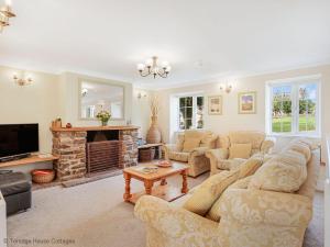 ein Wohnzimmer mit zwei Sofas und einem Kamin in der Unterkunft Hen Cottage in Little Torrington
