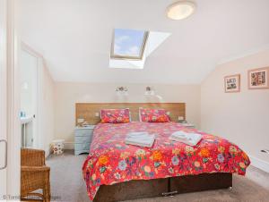 ein Schlafzimmer mit einem großen Bett mit einer roten Decke in der Unterkunft Hen Cottage in Little Torrington