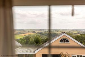 a window of a house with a view of the countryside at Hen Cottage in Little Torrington