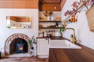 a kitchen with a fireplace and a sink at Rufloreo Flats 1 - central gem in Buxton +24 photos