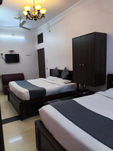 a hotel room with two beds and a chandelier at hotel blue star in Varanasi