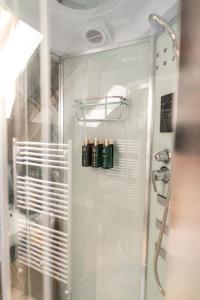 ein Bad mit einer Dusche mit 3 Flaschen in der Unterkunft Cabana din padure in Agapia