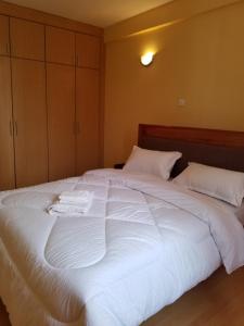 a bedroom with a large white bed with two pillows at Almasi airport view apartment in Syokimau