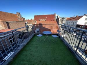 リエヴァンにあるVue sur les Toits - 2p Centre-villeのバルコニーにテーブルと椅子が置かれたパティオ