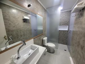 a bathroom with a sink and a toilet and a mirror at Motel Daponti in Alegrete +4 photos