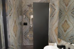 ein Badezimmer mit Dusche, Waschbecken und Spiegel in der Unterkunft Cabana din padure in Agapia + 6 Fotos