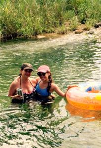 two women in the water next to a raft at Kay's River Escape in Utopia