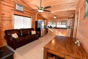 a living room with a leather couch and a refrigerator at Kay's River Escape in Utopia