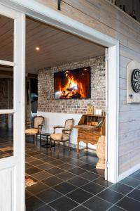 a fireplace on a patio with chairs and a table at Vakantiehoeve Amadee in Zonnebeke
