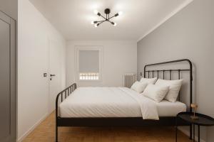 Un dormitorio blanco con una cama y un ventilador de techo. en Ca' Mia, en Borno