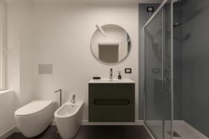 Un baño con inodoro, lavabo y espejo. en Ca' Mia, en Borno 21 fotos más