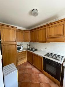 una cucina con mobili in legno e un forno a piano cottura di Haus Piller Cottrer Pietro a Sappada Altre 10 foto