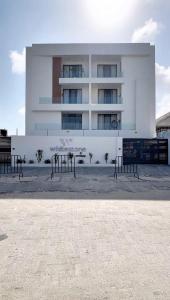 a white building with benches in front of it at White Stone in Lekki