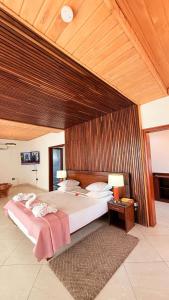 a bedroom with a large bed and a wooden ceiling at Coconut Grove Beach Resort in Elmina +133 photos