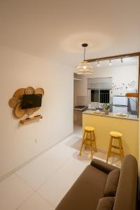 Una sala de estar con un sofá y una cocina. en Morada da Lena - Praia do Forte, en Farol