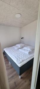 a bed in a room with a ceiling at Sandkaas Family Camping & Cottages in Allinge