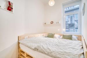 a bed in a white room with a window at Charming Downtown Apartment in Otilia