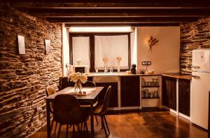 een keuken met een tafel met stoelen en een koelkast bij Casa Da Fragua in Samos