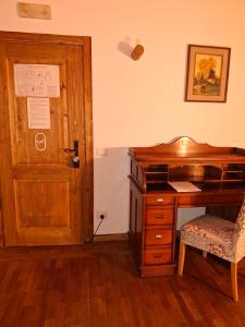 un bureau avec un bureau en bois et une porte en bois dans l'établissement Locanda Al Cacciatore, à Nervesa della Battaglia