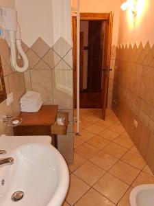 une salle de bain avec un lavabo, une douche et des toilettes dans l'établissement Locanda Al Cacciatore, à Nervesa della Battaglia