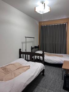 Postel nebo postele na pokoji v ubytování 駅本ビル民宿4階