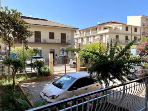 a car parked in a parking lot in front of a building at Il Giardino Segreto in Capo dʼOrlando