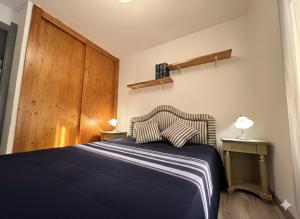 ein Schlafzimmer mit einem blauen Bett und einer Holztür in der Unterkunft 8 ARBOUSIERS VILLA 16 in Bonifacio + 7 Fotos