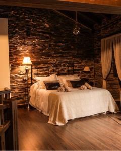 een slaapkamer met een bed en een stenen muur bij Casa Da Fragua in Samos