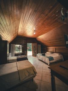 une chambre avec deux lits et un plafond en bois dans l'établissement Hotel Pousada Cata Branca, à Itabirito 85 autres photos
