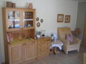 a living room with a cabinet and a chair at Ferienhaus Wiese in Bruchhausen