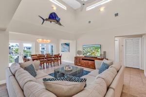 Una sala de estar con un sofá grande y una mesa. en Serene Home with Skiff Dockage & Access to Private Bayfront Beach, en Lower Matecumbe Beach
