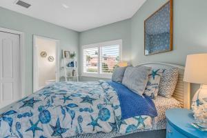 Un dormitorio con una cama azul y blanca y una ventana. en Serene Home with Skiff Dockage & Access to Private Bayfront Beach, en Lower Matecumbe Beach