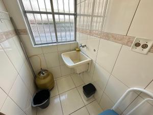 Un baño pequeño con lavabo e inodoro. en Guilhermina 250m do Mar! Com garagem!, en Praia Grande 28 fotos más