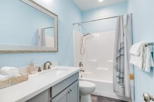 a bathroom with a white sink and a shower at Prime Beachfront Large Deck Family Fun in Port Bolivar +23 photos