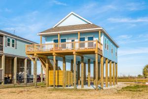a house with a large deck on the side of it at Prime Beachfront Large Deck Family Fun in Port Bolivar