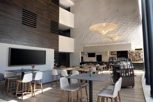 メキシコシティにあるNH コレクション メキシコシティ エアポート T2のテーブルと椅子、薄型テレビのあるレストラン +44枚の写真