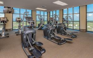 a gym with several treadmills and elliptical machines at The Oasis 2209 formerly Phoenix West II 2209 condo in Romar Beach +52 photos