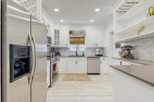 een keuken met witte kasten en roestvrijstalen apparaten bij Once Upon a Beach Time in Pompano Beach