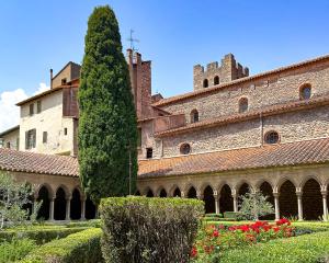 un grand bâtiment avec un arbre devant dans l'établissement Joli appartement avec jardin à 5 min des Thermes, à Arles-sur-Tech
