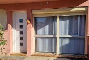 une fenêtre avec des rideaux bleus sur une maison dans l'établissement Joli appartement avec jardin à 5 min des Thermes, à Arles-sur-Tech